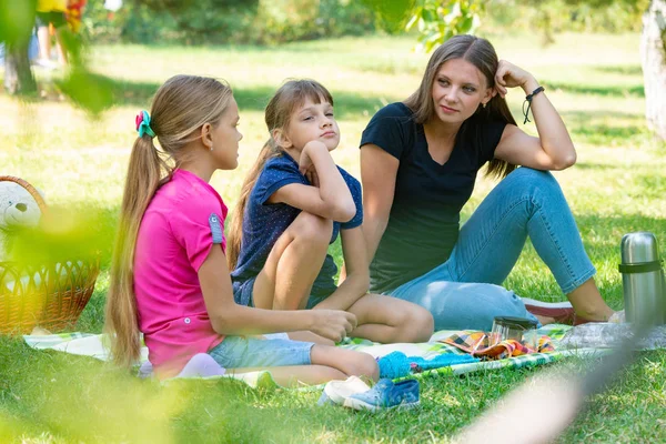 Сестры разных возрастов мило разговаривают на пикнике — стоковое фото