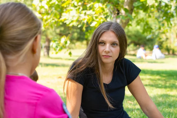 Flickan på en picknick lyssnar uppmärksamt på samtalspartnern — Stockfoto