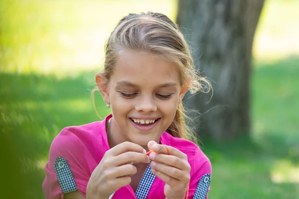 Porträt eines Mädchens, das bei einem Picknick in der Natur auf Stricknadeln strickt, Nahaufnahme — Stockfoto