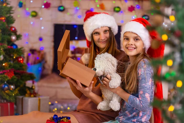 Mamá y su hija abrieron la caja de Navidad con un regalo y miraron en el marco —  Fotos de Stock