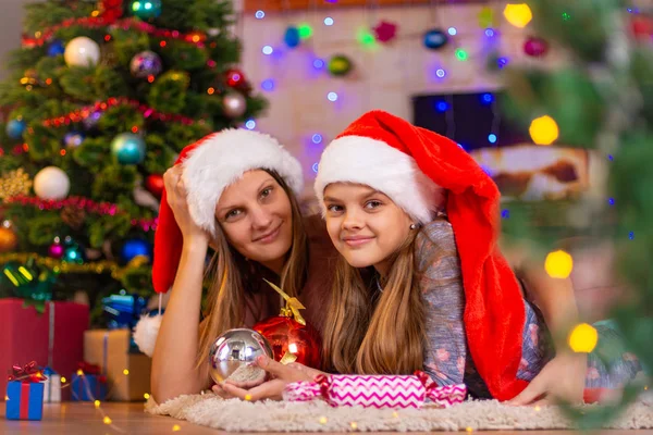 Girl and child lie on the mat in the New Year's interior — ストック写真