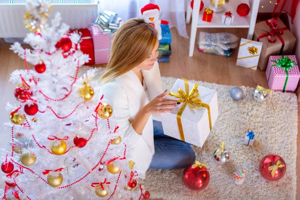 Chica abre regalo de Año Nuevo en el árbol de Navidad — Foto de Stock