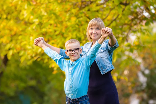 Mom and son seven-year-old son having fun in autumn park — Stock Photo, Image