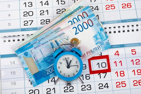 Calendario con un numero dedicato di 10, un pacchetto di soldi russi e un orologio — Foto Stock