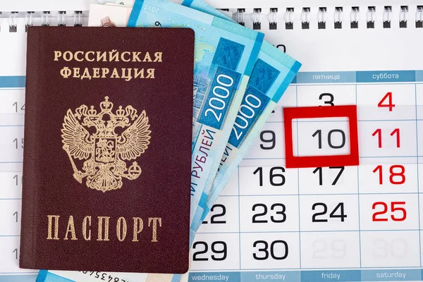 View from above on the calendar on which lies a passport with 2,000 ruble banknotes — Stock Photo, Image