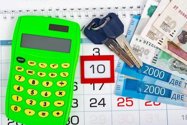 Calendario con il numero 10, calendario, calcolatrice, mazzo di chiavi e un pacchetto di rubli Russ — Foto Stock