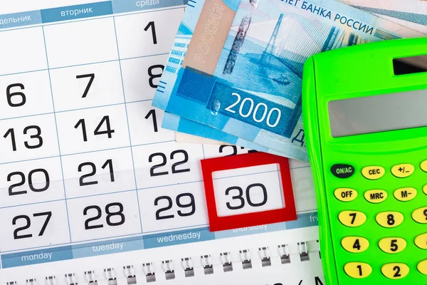 Calendario con un numero assegnato 30, russo due duemila banconote, calcolatrice — Foto Stock