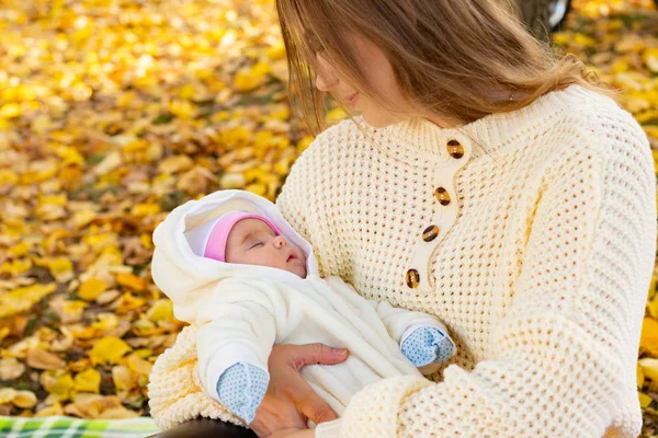Maman tient bébé dans ses bras sur la promenade dans le parc d'automne — Photo