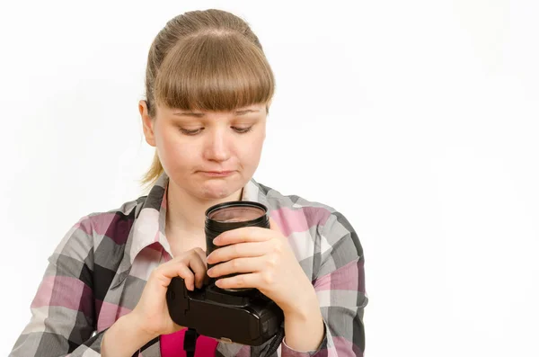 The girl looks sadly at the front lens of the lens on the camera — Stock Photo, Image