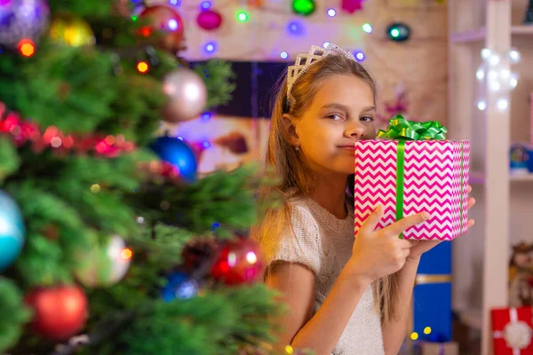 Chica feliz con un regalo en el árbol de Navidad —  Fotos de Stock