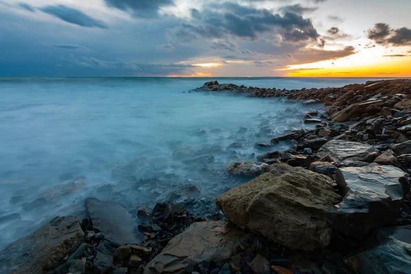 Морской пейзаж на закате, волны на берегу — стоковое фото