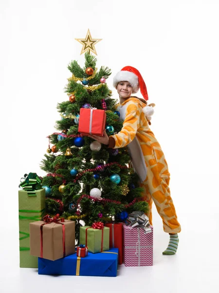 带着礼物的女孩抱着圣诞树 — 图库照片