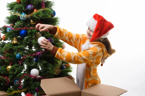 女孩从盒子里掏出圣诞树球 挂在圣诞树上 — 图库照片