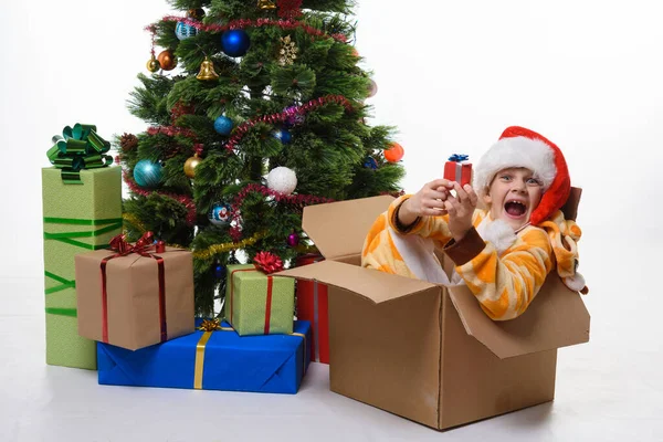 Menina Senta Uma Caixa Árvores Natal Perto Árvore Natal Alegremente — Fotografia de Stock