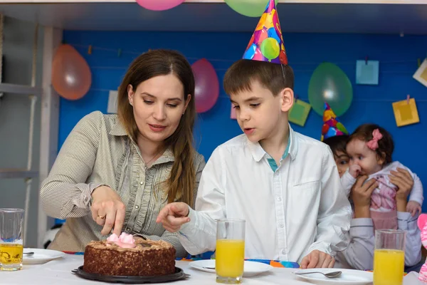 母亲和儿子切了一块蛋糕以庆祝生日 — 图库照片