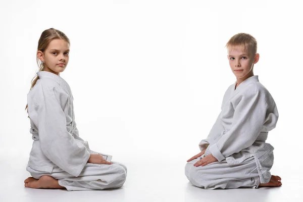 Uma Menina Menino Quimono Esportivo Sentam Lado Outro Olham Para — Fotografia de Stock