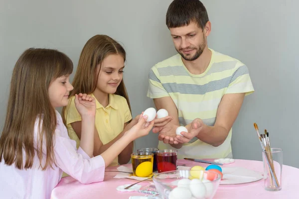 爸爸和女儿坐在桌旁 为复活节彩绘彩蛋 — 图库照片