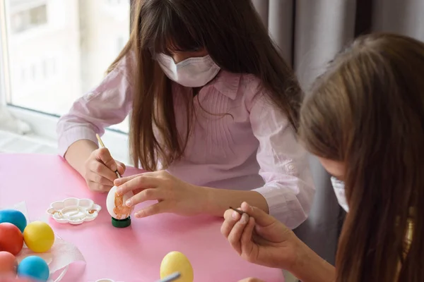 Dvě Dívky Lékařských Maskách Malovat Vejce Štětcem Při Přípravě Velikonoce — Stock fotografie