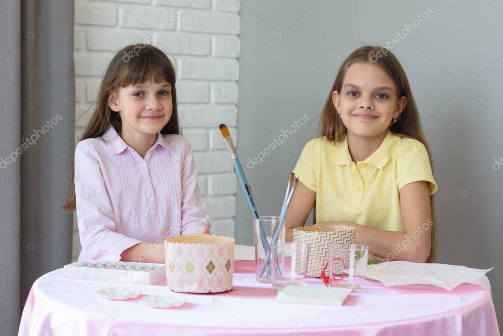 Children sit at the table and prepare for the celebration of Easter