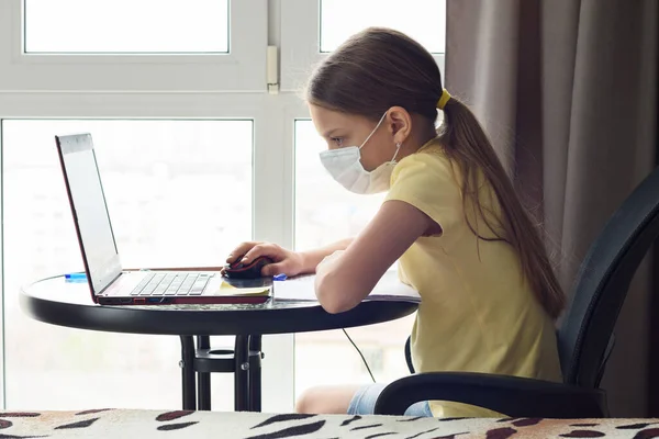 Dziewczyna Masce Medycznej Ogląda Lekcję Online Laptopie — Zdjęcie stockowe