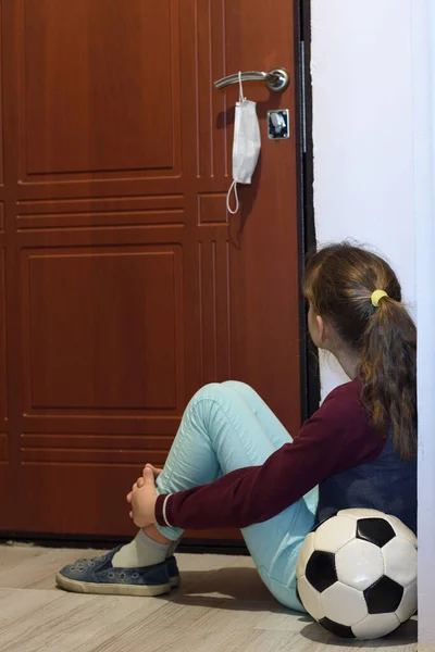 Девушка Сидит Коридоре Смотрит Дверь Ручке Которой Висит Защитная Медицинская — стоковое фото