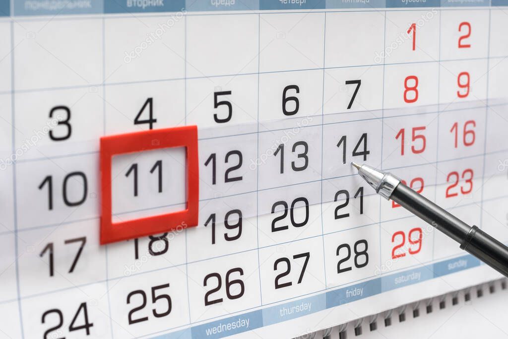 Pen indicates future friday on wall calendar