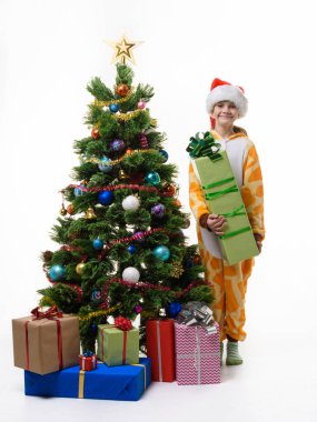 Bir kız Noel ağacının yanında duruyor büyük bir yılbaşı hediyesiyle