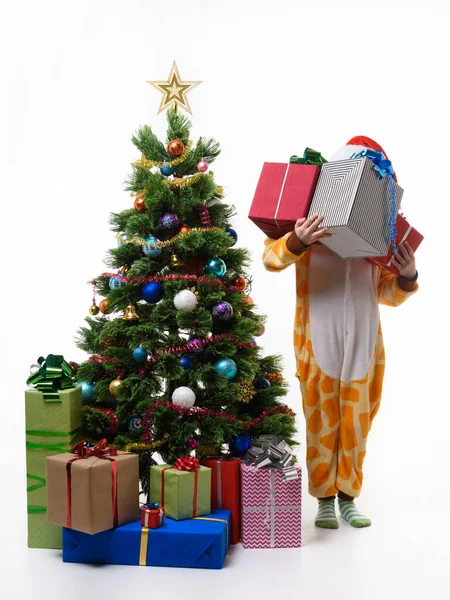 女孩拿着一堆礼物站在圣诞树旁 — 图库照片