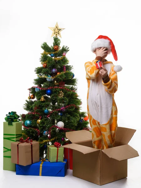 一个女孩站在一个盒子里 拿着一份新年礼物 用手捂住脸 — 图库照片