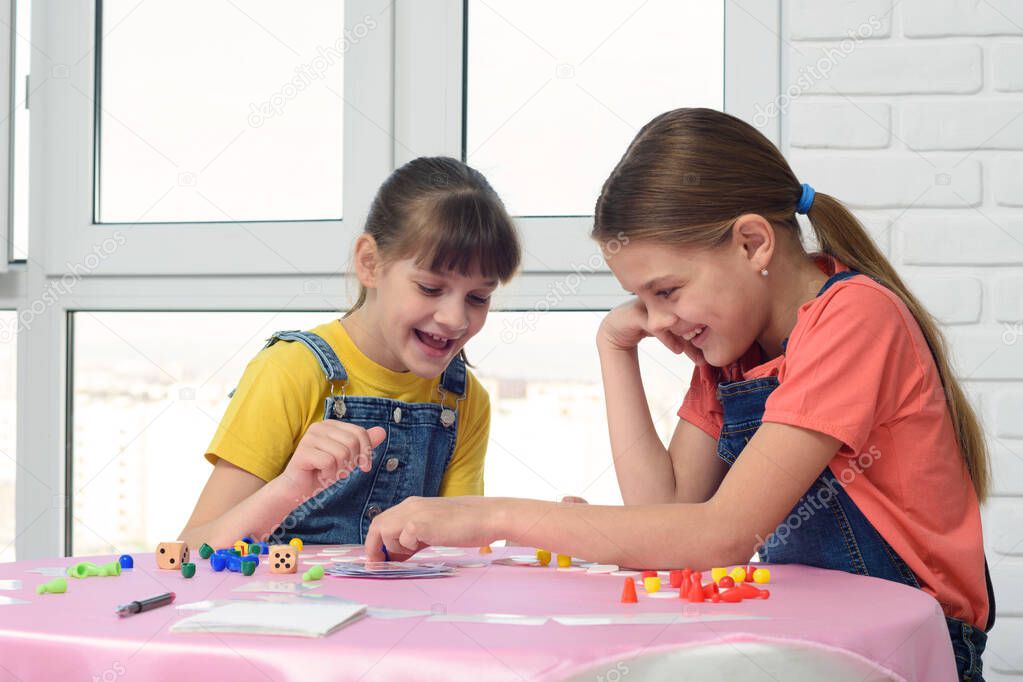 Two girls having fun playing a board game