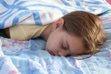 Tired girl fell asleep in the afternoon on the bed clipart