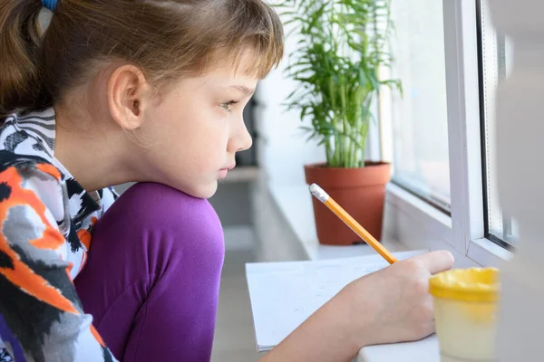 Het Meisje Tekent Attent Kijkt Uit Het Raam — Stockfoto