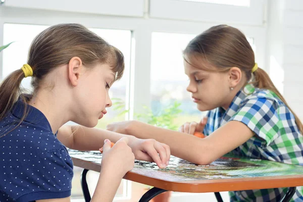 Két Lány Lelkesen Gyűjti Kirakósokat Otthon Asztalnál — Stock Fotó