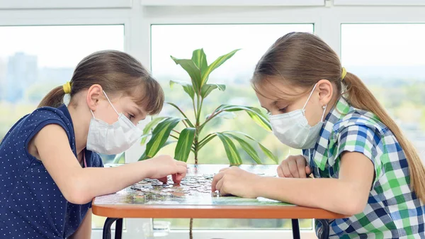 Two Girls Medical Masks Sit Table Play Board Games — Stock Photo, Image