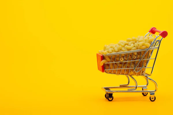 Carrinho Supermercado Cheio Macarrão Fundo Laranja Brilhante — Fotografia de Stock