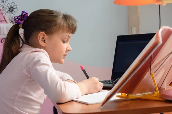 自宅で遠隔で勉強している女の子の側面図 — ストック写真