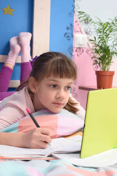 女子高生はタブレットコンピュータでビデオチュートリアルを見て ベッドに横たわっている — ストック写真