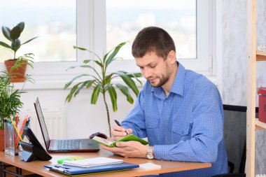 Ofisteki işadamı not defterine notlar yazıyor.