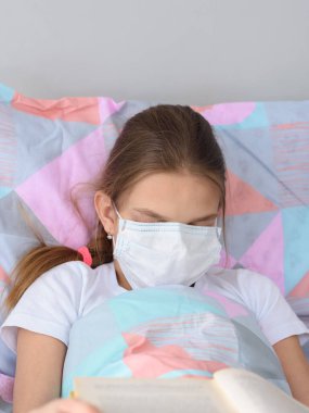Hasta kız kitap okurken uyumaya karar verdi ve yüzüne tıbbi bir maske taktı.