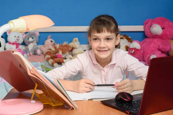 Het Meisje Kinderkamer Zit Aan Het Bureau Met Een Glimlach — Stockfoto