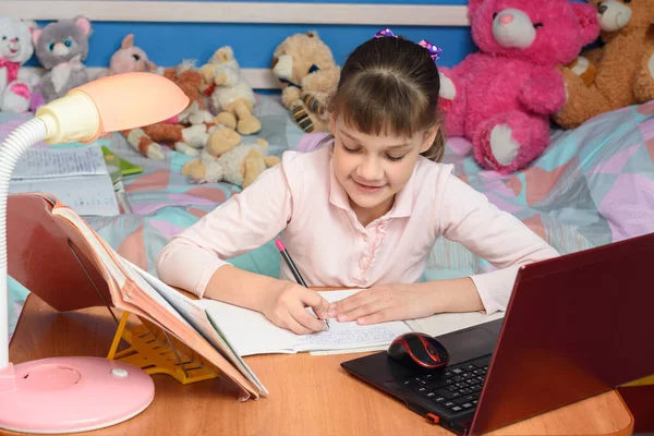 子供部屋には机の上に女の子が座って手作りの — ストック写真