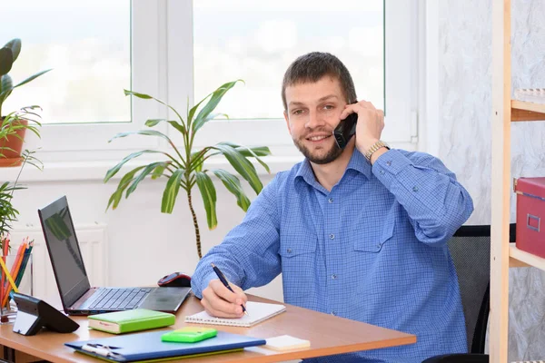 一位办公室职员在讲电话时面带微笑 面带微笑 免版税图库照片