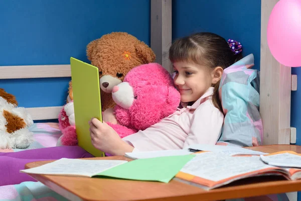 Neunjähriges Mädchen Liegt Mit Spielzeug Bett Und Schaut Auf Tablet — Stockfoto