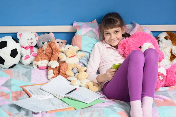 Ragazza Tra Giocattoli Siede Sul Letto Compiti — Foto Stock