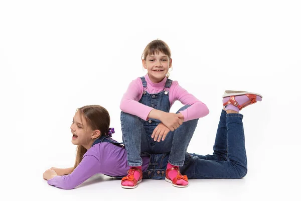 Glückliches Mädchen Sitzt Auf Dem Rücken Ihrer Schwester Vor Weißem — Stockfoto