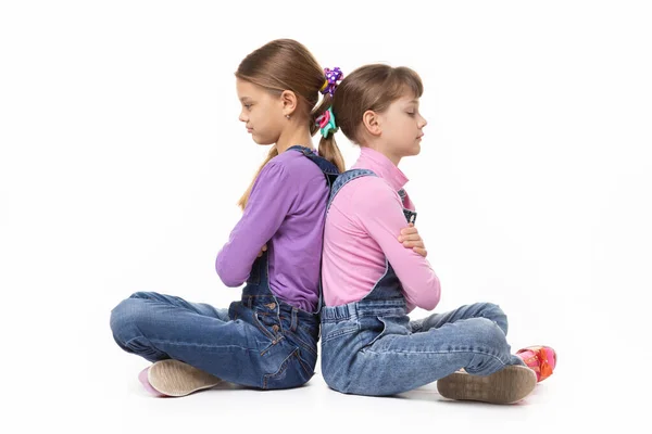两个吵吵闹闹的女孩背靠背地坐在一起 脸色苍白 — 图库照片