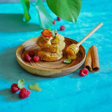 Sağlıklı kahvaltı süzme peynirli krep, ballı ve böğürtlenli ahşap tabakta