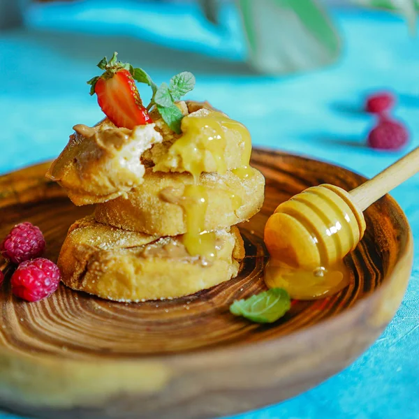 healthy breakfast cottage cheese pancakes with honey and berries on a wooden plate