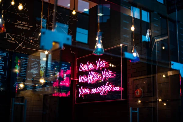 Primo piano del cartello aperto al neon all'esterno di una piccola azienda caratteristica Natale articoli per le vacanze dark urban blue shop — Foto Stock