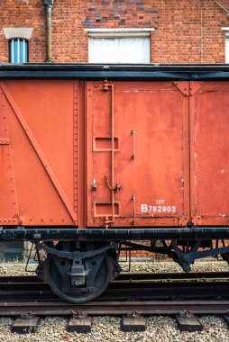 Eski terk edilmiş tren vagonu bilim müzesinin dış duvarına yakın çekim. Sıcak renkli yazılar için Manchester alanı. Paslı tekerlek rayları antika.